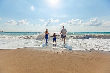 Familie am Strand. Familie mit Kind steht am Strand in der Brandung.